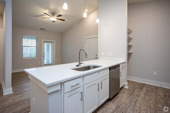 an empty kitchen with a large counter top and a sink