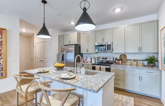 a kitchen with white cabinets and a marble counter top