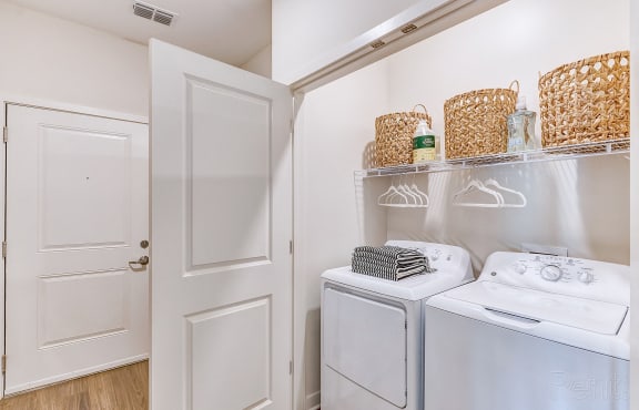 a washer and dryer in a laundry room with white walls and white doors
