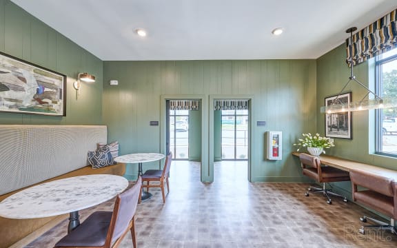a living room with green walls and a table and chairs