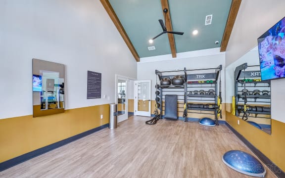 a fitness room with a fire place and weights on a rack