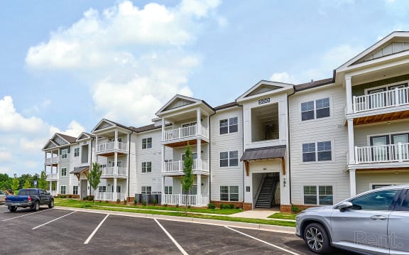 an apartment building with cars parked in front of it