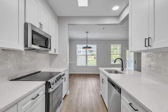 A kitchen with white cabinets and a black stove top oven.