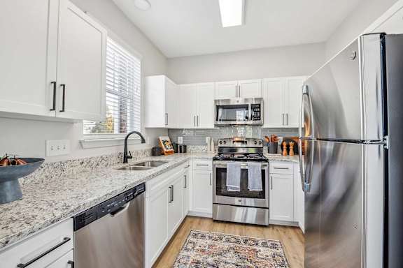 A kitchen with white cabinets and stainless steel appliances.