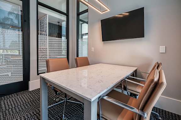 a conference room with a marble table and chairs at Altis Twin Lakes Apartments, Kissimmee