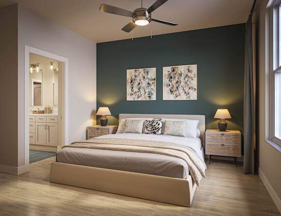 Three-Bedroom Luxury Apartments in Bradenton, FL - Eventide Apartments - Bedroom With Wood-Grain Plank Flooring, Large Bed, Ceiling Fan, Matching Nightstands, Private Bathroom, and Large Window.