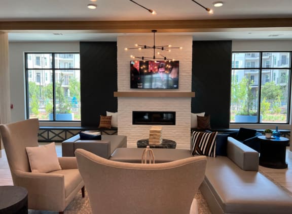 a living room with chairs and a table and a fireplace