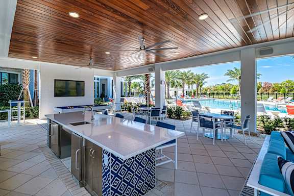 A kitchen with a wooden ceiling and a pool in the backyard