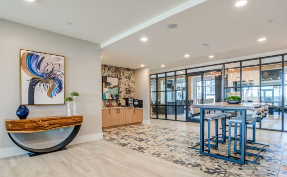the living room of a condo with a table and a sink