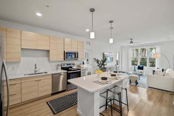 A modern kitchen with a large island and a dining area.