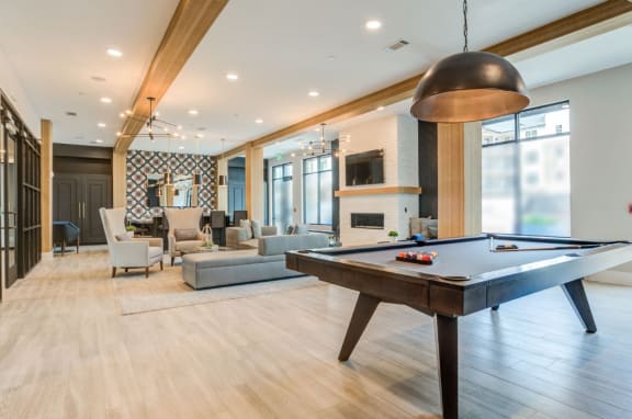 an open living room with a pool table and couches