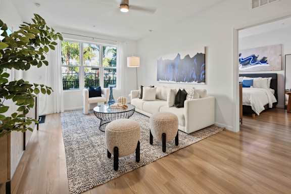 A living room with a white couch and a rug.