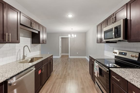 an empty kitchen with granite counter tops and stainless steel appliances