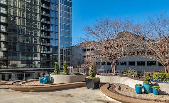 A courtyard with a circular design and a tall building in the background.