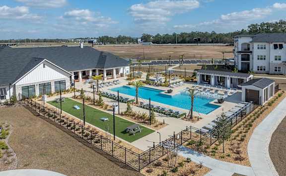 A large outdoor swimming pool surrounded by a black fence.