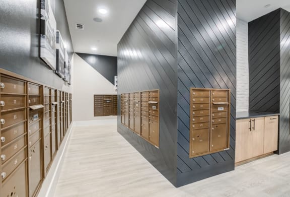 a view of the mail room in a building with many mailboxes and a wall