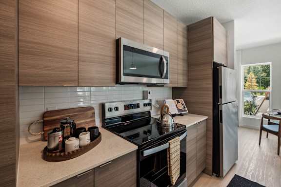A modern kitchen with a stove top oven and a microwave above it.