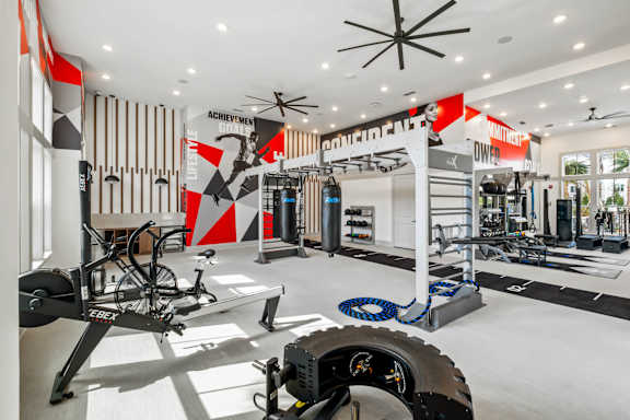 A gym with a variety of equipment including a treadmill, weights, and a bicycle.at Altis Grand Lake Willis, Orlando, 32821