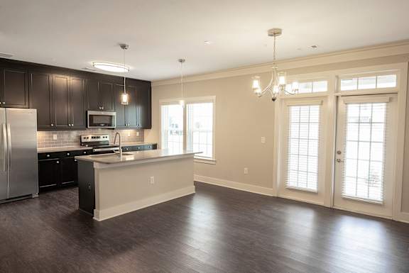 A kitchen with a refrigerator, microwave, and oven.