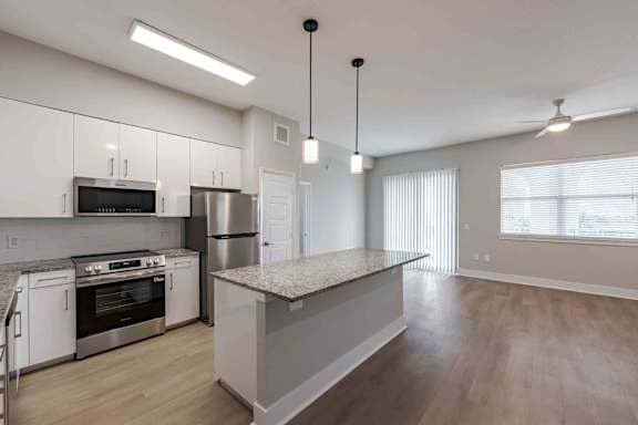 A modern kitchen with stainless steel appliances and a central island.
