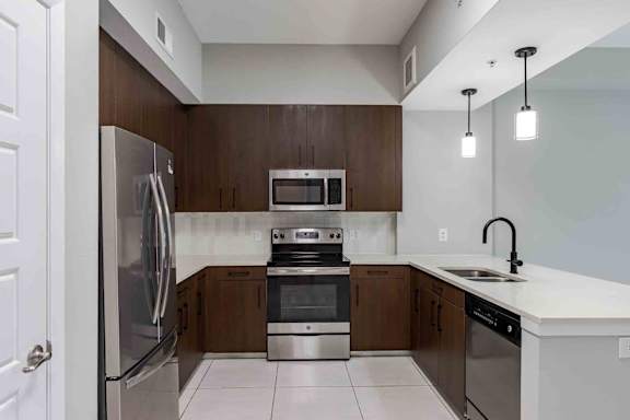 A modern kitchen with stainless steel appliances and wooden cabinets.