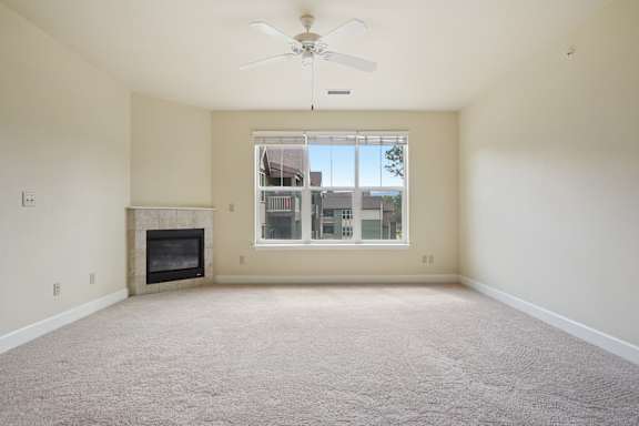A room with a fireplace and a ceiling fan.