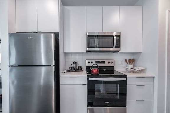 A modern kitchen with a stainless steel refrigerator and a black oven.
