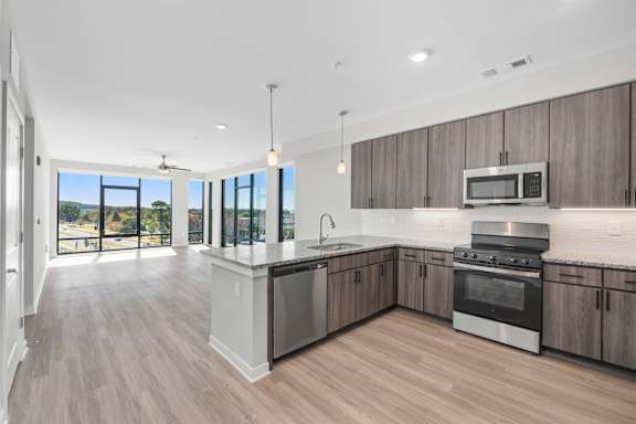A modern kitchen with wooden cabinets and stainless steel appliances.