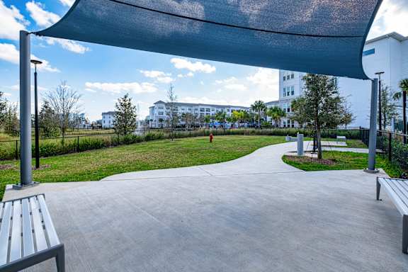 A park with a walkway, benches, and a canopy.at Altis Grand Lake Willis, Orlando Florida