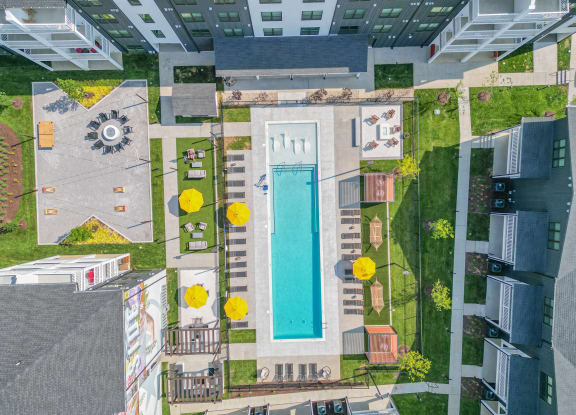 a birds eye view of a swimming pool in the middle of a building with grass