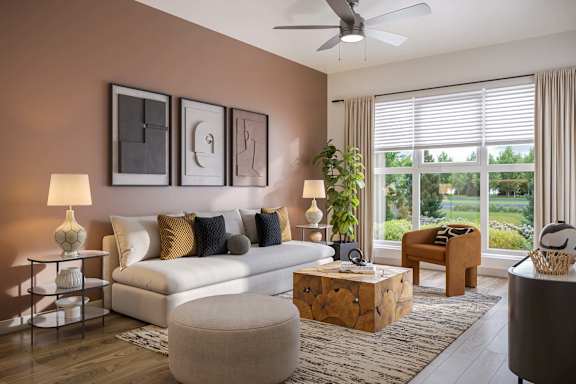 A living room with a white couch, a wooden coffee table, and a large window with blinds.