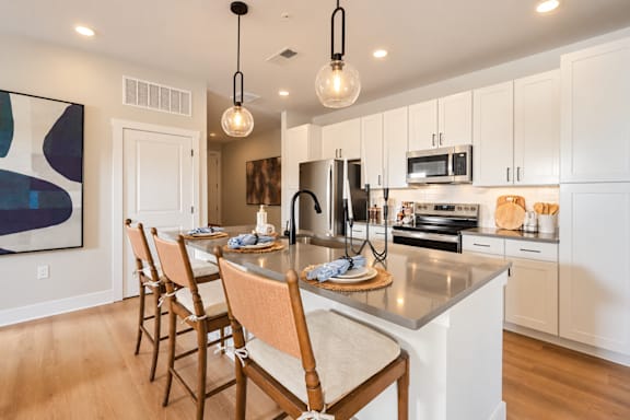 A kitchen with a table and chairs and a painting on the wall.