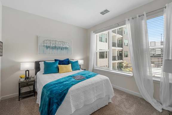 A bedroom with a large bed and a painting on the wall.