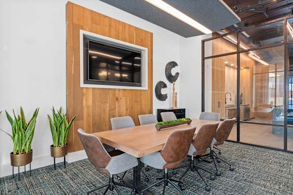 A conference room with a wooden table and chairs.