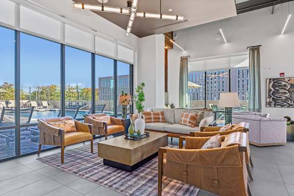 A living room with a large window overlooking a pool and trees.
