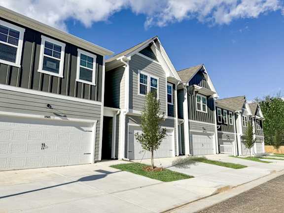A row of houses with garages and driveways.