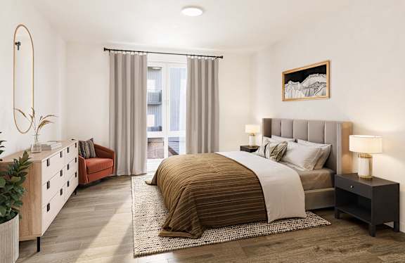 A bedroom with a large bed and a red chair.