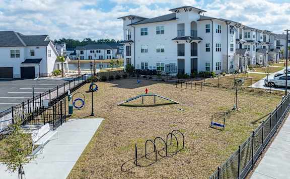 A playground with a swing set and a basketball hoop in the middle of a grassy area.
