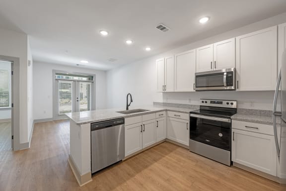 a renovated kitchen with white cabinets and stainless steel appliances