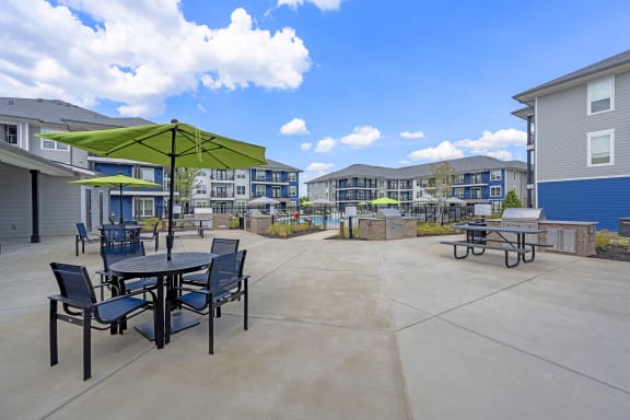 our apartments have a patio with tables and chairs and umbrellas