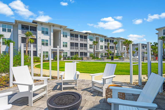 a patio with chairs and a firepit at the enclave at woodbridge apartments in sugar land