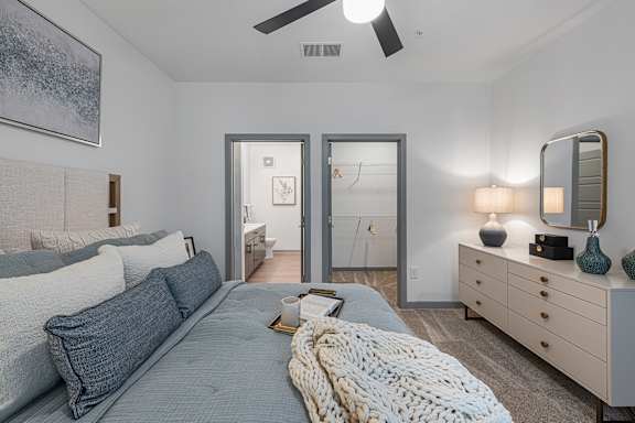 A bedroom with a bed, dresser, and mirror.