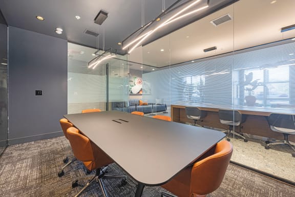 a conference room with a table and orange chairs