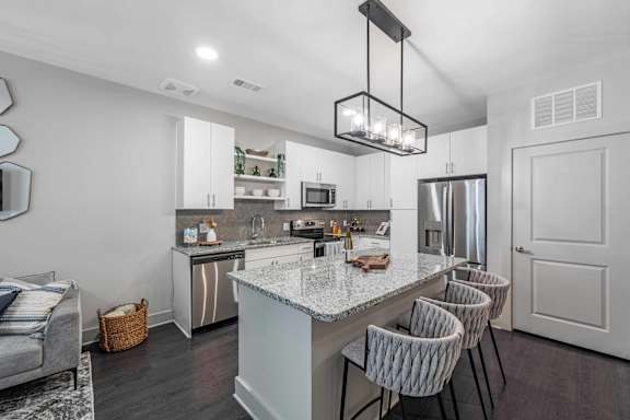 A modern kitchen with a large island and a dining area.