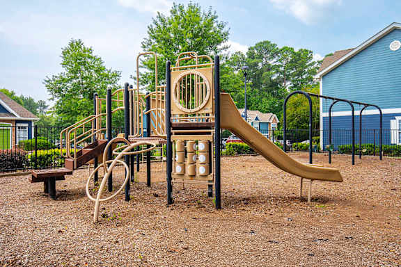 A playground with a slide, swings, and a monkey bars.