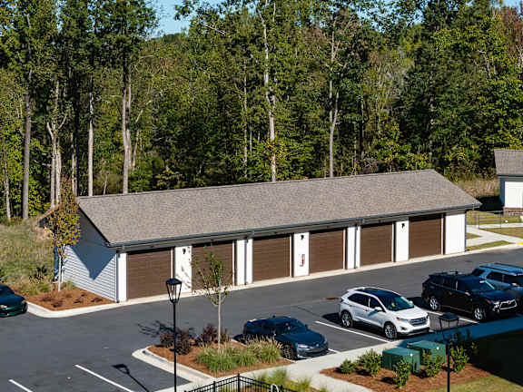 A car dealership with a white building and several cars parked outside.