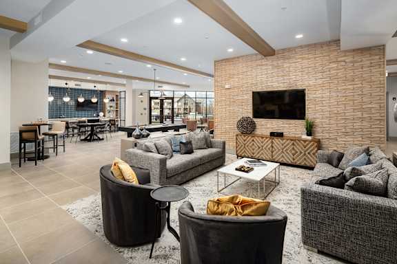 A modern living room with a brick wall and a flat screen TV.