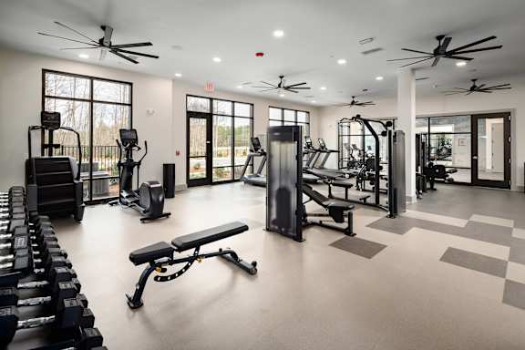 A spacious gym with a variety of equipment including treadmills, weights, and exercise machines.