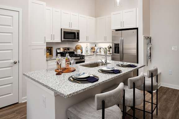 A kitchen with a granite countertop and white cabinets.