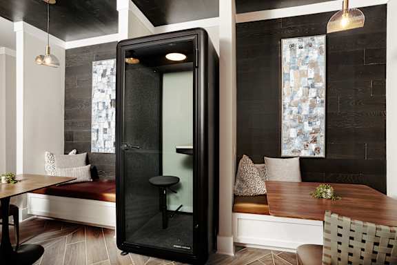 A modern bathroom with a glass shower door and a wooden table.